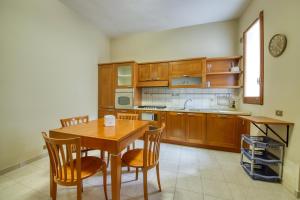 a kitchen with wooden cabinets and a table and chairs at Pellicciari 14 - Affitti Brevi Italia in Gravina in Puglia