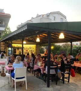 een groep mensen aan tafel in een restaurant bij Unver Holiday Homes in Marmaris