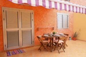 a dining room with a table and chairs and an awning at EDEN RENTALS Caletillas Peace in Candelaria