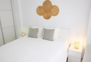 Dormitorio blanco con cama blanca y almohadas blancas en EDEN RENTALS Caletillas Peace en Candelaria