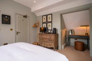 Schlafzimmer mit einem Bett, einem Schreibtisch und einem TV in der Unterkunft The Bottle & Glass Inn - Garden View - Room 1 in Henley on Thames