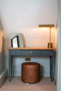a blue desk with a mirror and a stool at The Bottle & Glass Inn - Garden View - Room 1 in Henley on Thames