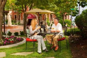 two people sitting at a table under an umbrella at Portland Regency Hotel & Spa in Portland