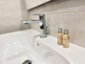 two bottles of seasoning sitting on a bathroom sink at Pellicciari 14 - Affitti Brevi Italia in Gravina in Puglia +11 photos