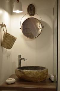 a bathroom with a stone sink and a mirror at Hemeros Villa in Zefiría