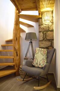 uma cadeira num quarto com um candeeiro e escadas em Hemeros Villa em Zefiría