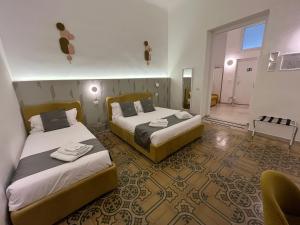 a hotel room with two beds in a room at Dimora Fantasia Charme B&B in Bari