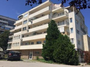 a tall white building with a tree in front of it at El MATE apartment Sea Garden and Beach Varna in Varna City