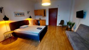 a large bedroom with a bed and a couch at METRO Pokoje & Apartamenty in Sopot