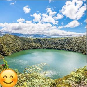 uma cara sorridente sentada em frente a um lago em Camping el triunfo em Montecillo