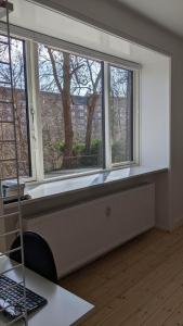 コペンハーゲンにあるCozy newly renovated apartment in Copenhagenのデスク、コンピューターが備わる客室で、窓のないシルが付いています。