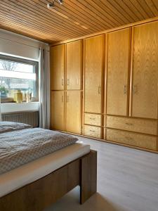a bedroom with wooden cabinets and a bed with a window at Ferienhaus Mone in Monschau