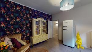 una sala de estar con una pared cubierta de papel pintado con motivos florales en SintPieter17 Lo-Ghis vakantiewoning, en Voeren