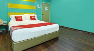 a bedroom with a large bed with red pillows at Juru Hotel in Bukit Mertajam