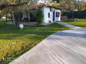 a walkway in front of a house with a yard at katerina house in Ormos Panagias