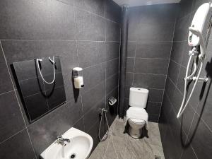 Juru Hotel في بوكيت ميرتاجام: حمام به مرحاض أبيض ومغسلة