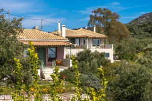 una casa en una colina con árboles en primer plano en Chamaloni Cottages, en Finikounta