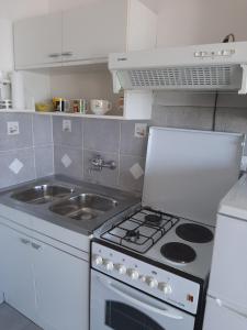 Il comprend une petite cuisine équipée d'une cuisinière et d'un évier. dans l'établissement Apartman Posavac, à Crikvenica