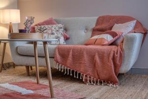 ein Wohnzimmer mit einem Sofa und einem Tisch in der Unterkunft Cottage Au Coin du Feu in Rambouillet