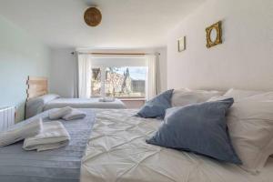 1 dormitorio con 1 cama grande con almohadas y ventana en Vila Cristina, en Valdemorillo