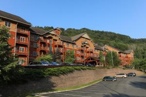 una fila de edificios de apartamentos con coches estacionados en un estacionamiento en Kaatskill Mountain Club and Condos by Hunter Mountain en Hunter