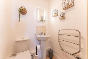Baño blanco con aseo y lavamanos en CITY CENTRE FLAT With Free Parking, Fast Wifi, Smart TV And 2 Bathrooms, 7min walk from Train Station!, en Coventry