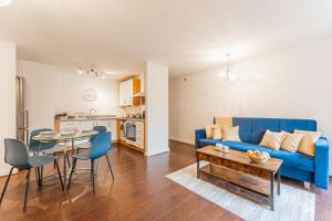 a living room with a blue couch and a table at CONTRACTORS & RELOCATION Friendly City Centre Flat - Disable People Welcome - Free Parking, Fast Wifi, Smart TV And 2 Bathrooms, 7min walk from Train Station! in Coventry +7 photos