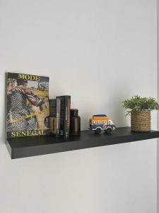 a shelf with books and a toy car on it at 2br modern apartment in Almadies in Dakar