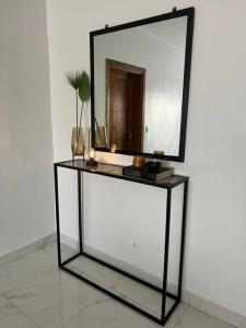 a mirror sitting on top of a stand with a shelf at 2br modern apartment in Almadies in Dakar