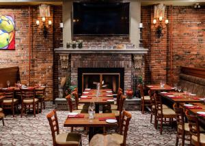 a restaurant with tables and chairs and a fireplace at Kingston Hotel in Vancouver