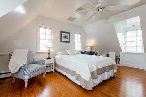 een witte slaapkamer met een bed en een plafondventilator bij Ferry Bridge House in Easton