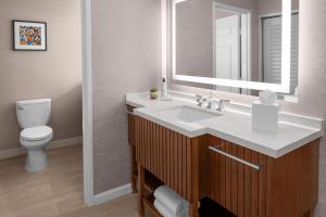 W łazience znajduje się umywalka, toaleta i lustro. w obiekcie Tommy Bahama Miramonte Resort & Spa w mieście Indian Wells