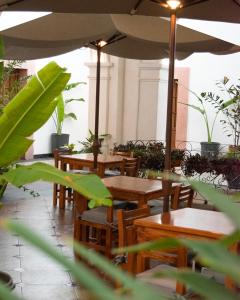 un restaurante con mesas, sillas y sombrilla en Hotel Catedral en Cuernavaca