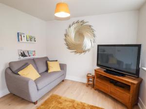 a living room with a couch and a flat screen tv at Cheshire View in Buxton