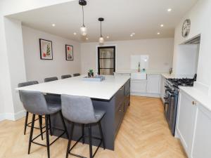 a kitchen with a large island with a white counter top at Cheshire View in Buxton