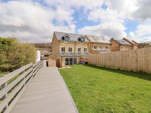 a wooden walkway leading to a house with a fence at Cheshire View in Buxton