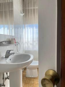 a white bathroom with a sink and a toilet at Hostal El Botero in Monreal del Campo