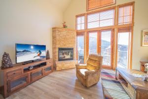 uma sala de estar com uma televisão, uma cadeira e uma lareira em Antlers Gulch 502 em Keystone