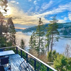 薩普斯堡的住宿－Kunstnerhytte med panoramautsikt på Furuholmen，阳台配有桌椅,享有湖景