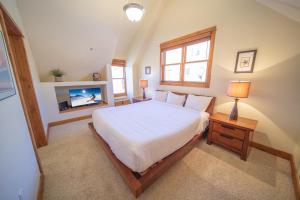 a bedroom with a white bed and a tv at Antlers Gulch 502 in Keystone