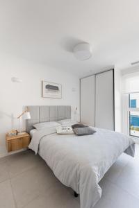 biała sypialnia z dużym łóżkiem i oknem w obiekcie Turquesa del Mar - Max Beach Golf - Large Sunny Terrace Apartment w mieście Playa Flamenca +24 zdjęcia