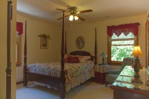 um quarto com uma cama e uma ventoinha de tecto em Secluded Chalet - Pet Friendly em Columbus