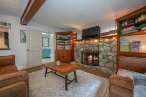 ein Wohnzimmer mit einem Steinkamin und einem Tisch in der Unterkunft Peaceful Country House With Fireplace And Firepit in Mill Spring