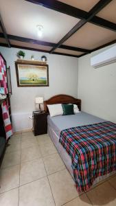 Un dormitorio con una cama con una manta de colores. en Tía Mema Hostal, en Santa Ana