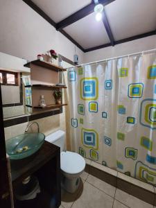 a bathroom with a shower curtain and a toilet at Tía Mema Hostal in Santa Ana