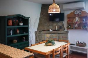 a dining room with a table and a fireplace at Primor Serra AL in Covilhã