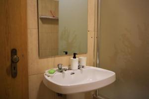 y baño con lavabo blanco y espejo. en Primor Serra AL, en Covilhã