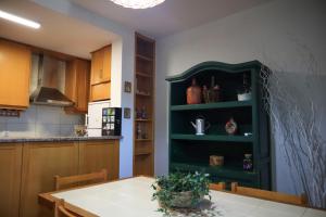a kitchen with a table and a green shelf at Primor Serra AL in Covilhã +14 photos