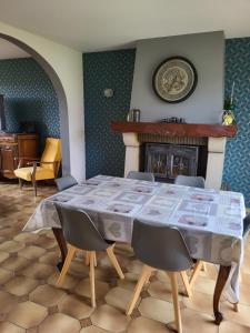 a dining room with a table and a fireplace at La maison du cœur in Saint-Moreil