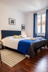 a bedroom with a large bed with blue curtains at Au coeur de Perpignan in Perpignan